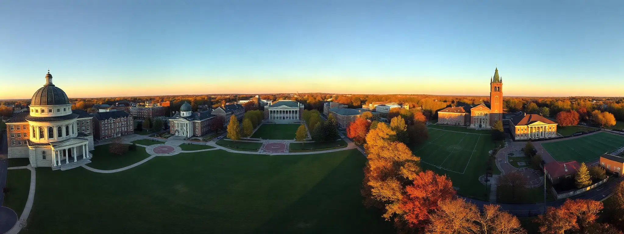 Aerial panorama of mai College at golden hour: a domed library, an observatory, a colonnaded hall, a dormitory, a bell tower and the playing fields.